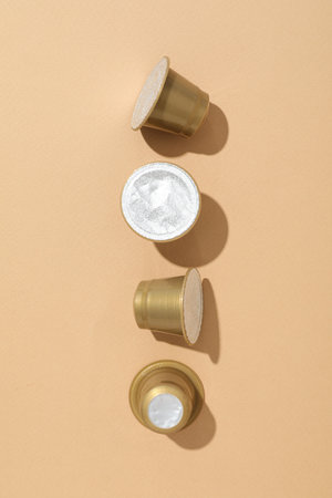 Golden coffee capsules on beige background, top viewの写真素材