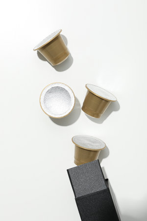 Golden coffee capsules on black box on white background, top viewの写真素材