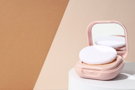 A bottle of powder, light shade, on a beige background.の写真素材