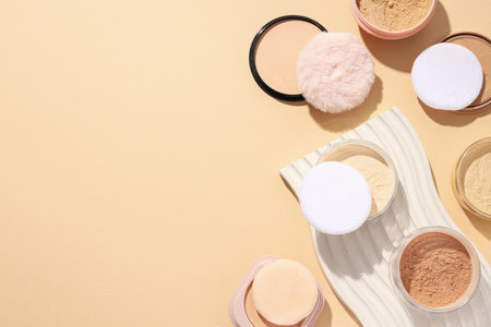 Bottles of face powder, different shades, on a pastel background.の写真素材