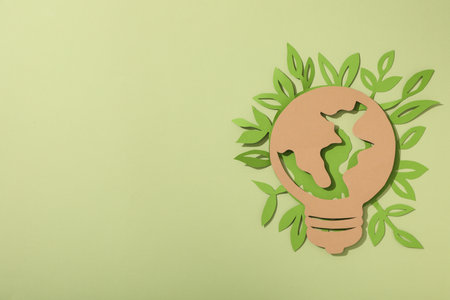The light bulb is cut out of paper with leavesの写真素材
