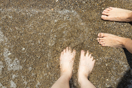 A man walks barefoot on the sand on the beach.の写真素材