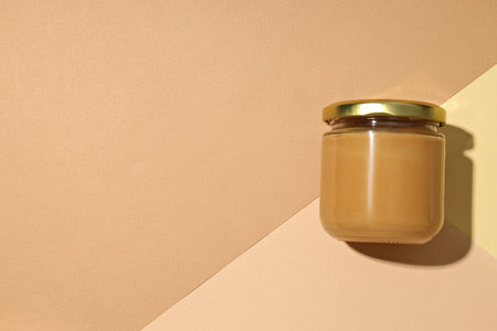 Peanut paste in a glass jar, on a light background.の写真素材