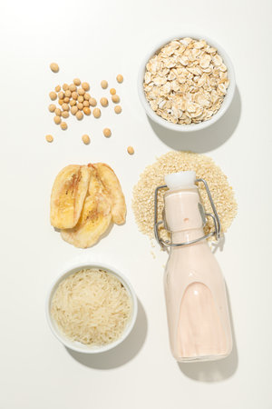 Bottle of alternative milk and herbal ingredients on white background, top viewの写真素材