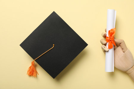 Graduate hat and diploma on yellow background.の写真素材
