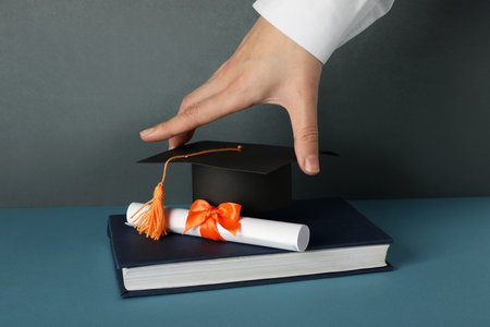 The hat of a university graduate, in his hands.の写真素材