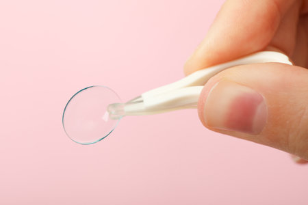 Plastic tweeters hold a clear eye lens close-upの写真素材