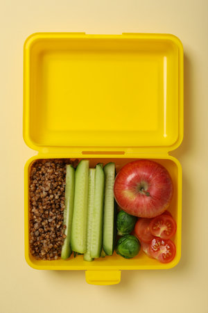 Yellow lunch box with buckwheat and fresh vegetablesの写真素材
