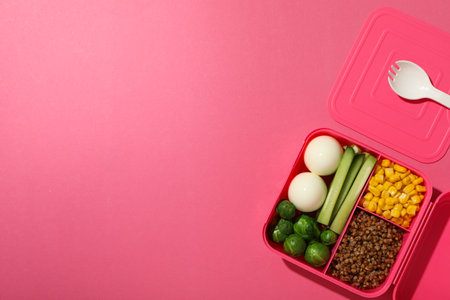 Pink lunch box with healthy food on a pink backgroundの写真素材