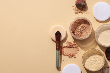 Bottles of face powder, different shades, on a pastel background.の写真素材