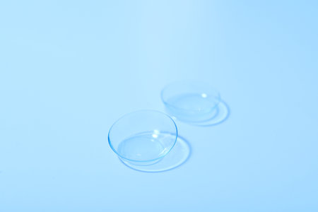 Transparent contact lenses for eyes on a blue backgroundの写真素材