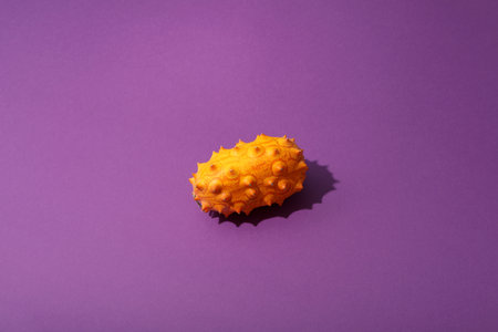 One whole kiwano fruit on purple background, top viewの写真素材