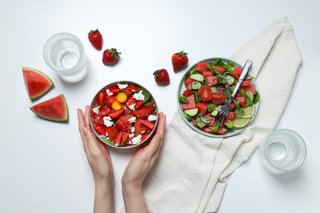 Watermelon salad in bowls with strawberries on a white backgroundの写真素材