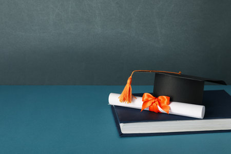 Graduate hat and books, on a blue background.の写真素材