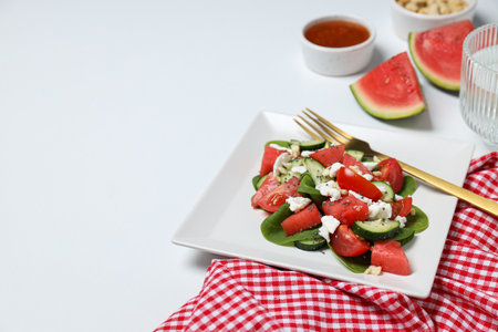 Watermelon salad in a square bowl on a white backgroundの写真素材