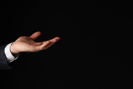 Businessman's hand close-up on a black backgroundの写真素材
