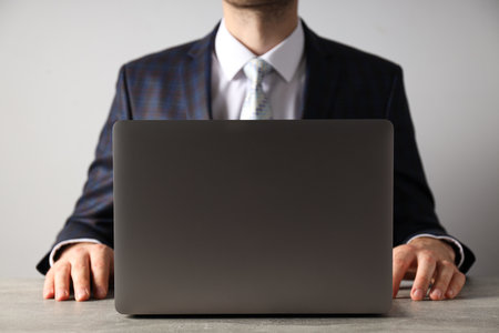 A man in a suit works on a laptopの写真素材