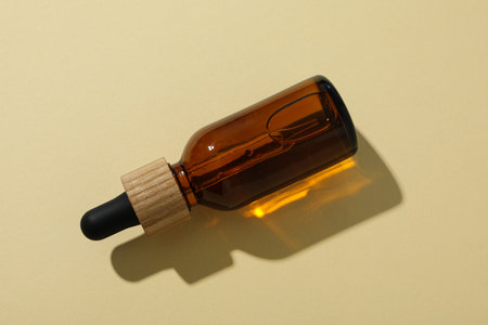 Cosmetic oil in a brown bottle on a light backgroundの写真素材