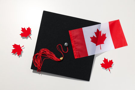 Graduate hat with Canadian flag on light backgroundの写真素材