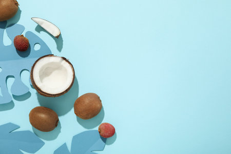 Set of tropical fruits and paper tropical leaves on blue background, space for textの写真素材