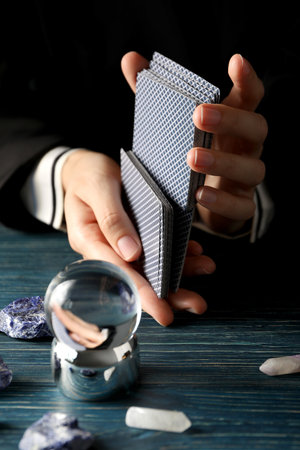 A tarologist makes a spread, on a dark background.の写真素材