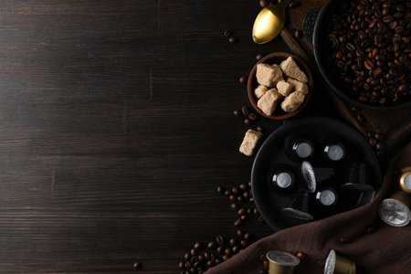 Coffee capsules, coffee beans and sugar on wooden background, space for textの写真素材
