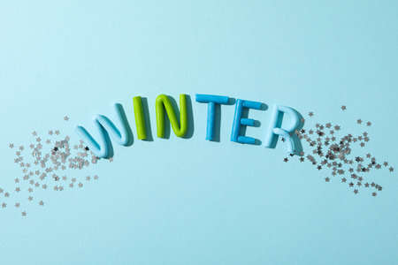 The word "winter" is made of colored plasticine on a blue background.の写真素材