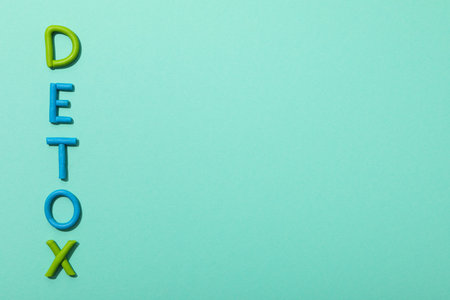 The word "detox" is made of colored plasticine on a turquoise background.の写真素材