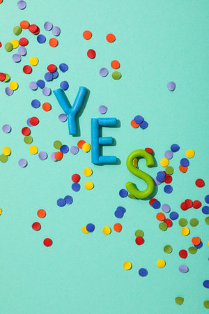 The word "yes" is made of colored plasticine on a turquoise background.の写真素材