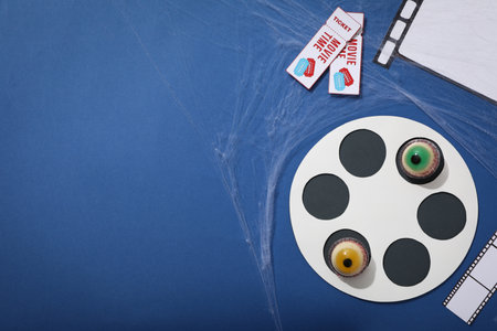 Reel, paper films, tickets and jelly eyes on blue background, space for textの写真素材