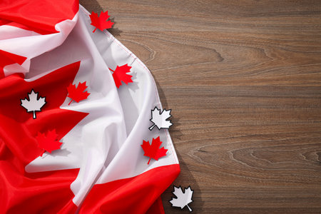 Canadian flag with decorative maple leaves on a wooden backgroundの写真素材