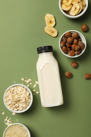 Bottle of alternative milk and herbal ingredients on green background, top viewの写真素材