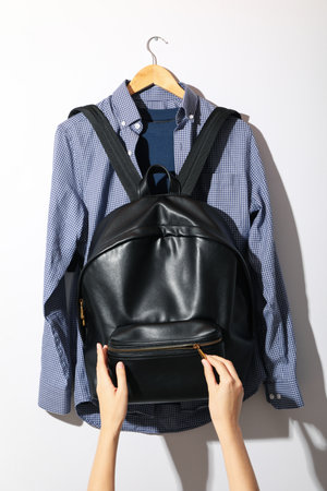 T-shirt, shirt, backpack on hanger and hands on white backgroundの写真素材