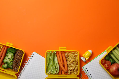 Yellow lunch box with delicious food and school suppliesの写真素材