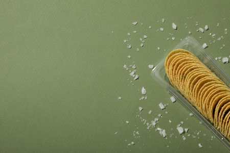 Potato chips in a plastic tray on a green backgroundの写真素材
