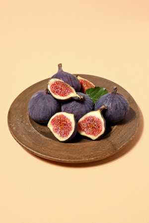Fresh ripe figs in a wooden bowl on a light backgroundの写真素材