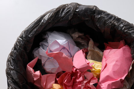 Bucket with garbage bag and papers on white background, close upの写真素材