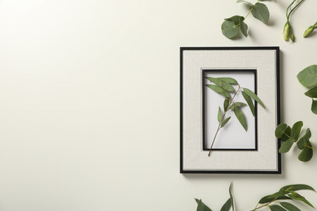 Fresh plants and photo frame on light background, space for textの写真素材