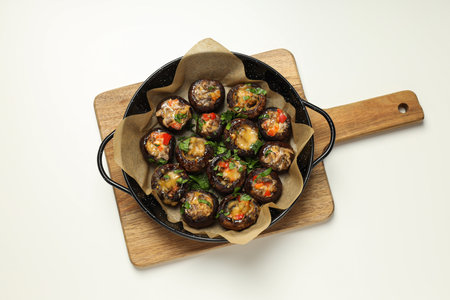 Stuffed mushrooms in frying pan on kitchen board on white background, top viewの写真素材