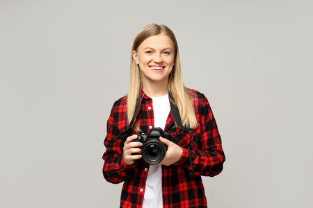 Cheerful girl photographer, on a gray background.の写真素材