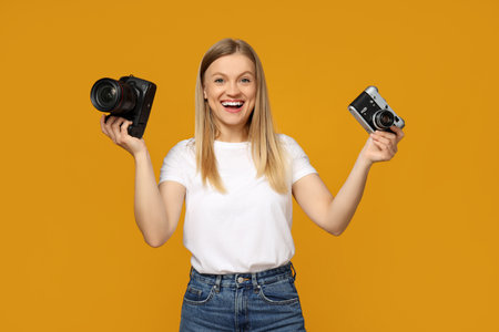 Beautiful girl photographer in the photo studio, on a yellow background.