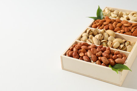 Wooden box with different nuts on a light backgroundの写真素材