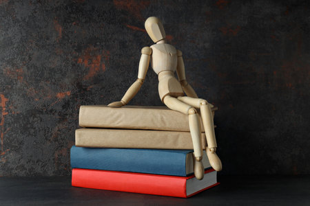 Books with a wooden man on a dark backgroundの写真素材