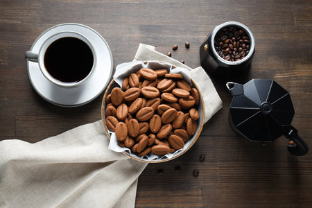 A cup of coffee with cookies on a dark backgroundの写真素材