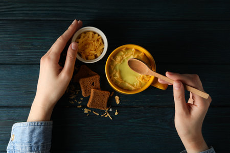 Cheese soup in a yellow cup on a wooden table