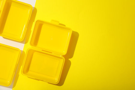 Yellow lunch box on a yellow backgroundの写真素材