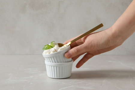 Ricotta in a bowl with herbs on a light background