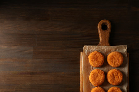 Fried mozzarella on a wooden board on a dark backgroundの写真素材