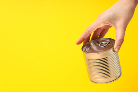 Can with food, on a yellow background.