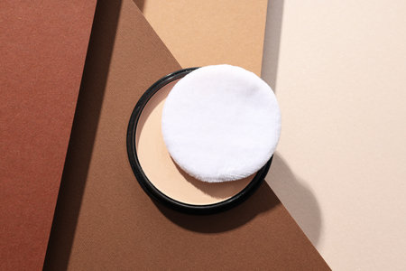 A bottle of powder, light shade, on a beige background.の写真素材